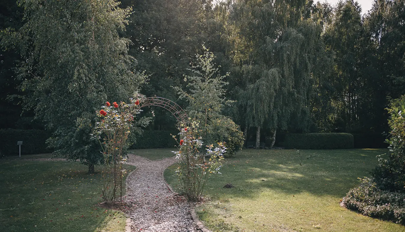 Romantisch berankter Rosenbogen im Garten des ROSENGARTEN-Tierkrematoriums Pritzwalk.