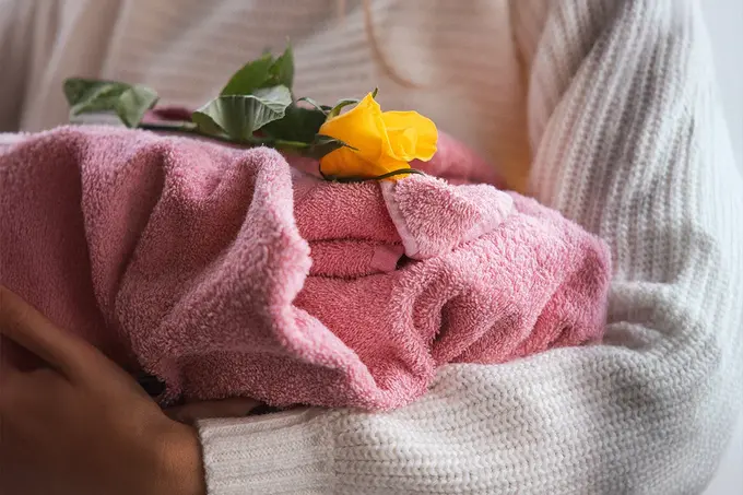 In eine Decke gehülltes Tier mit gelber Rose als stiller Abschied