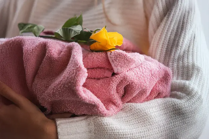 In eine Decke gehülltes Tier mit gelber Rose als stiller Abschied