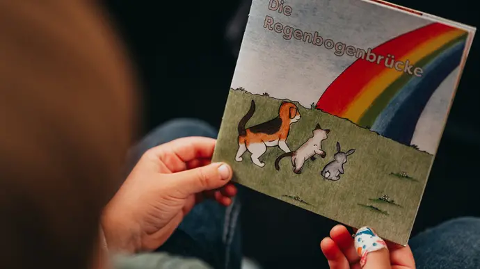 Kind hält Kinderbuch zur Trauerbewältigung in den Händen.