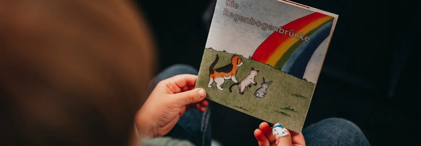 Kind hält Kinderbuch zur Trauerbewältigung in den Händen.