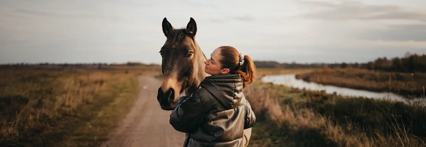 Frau spaziert mit Pferd