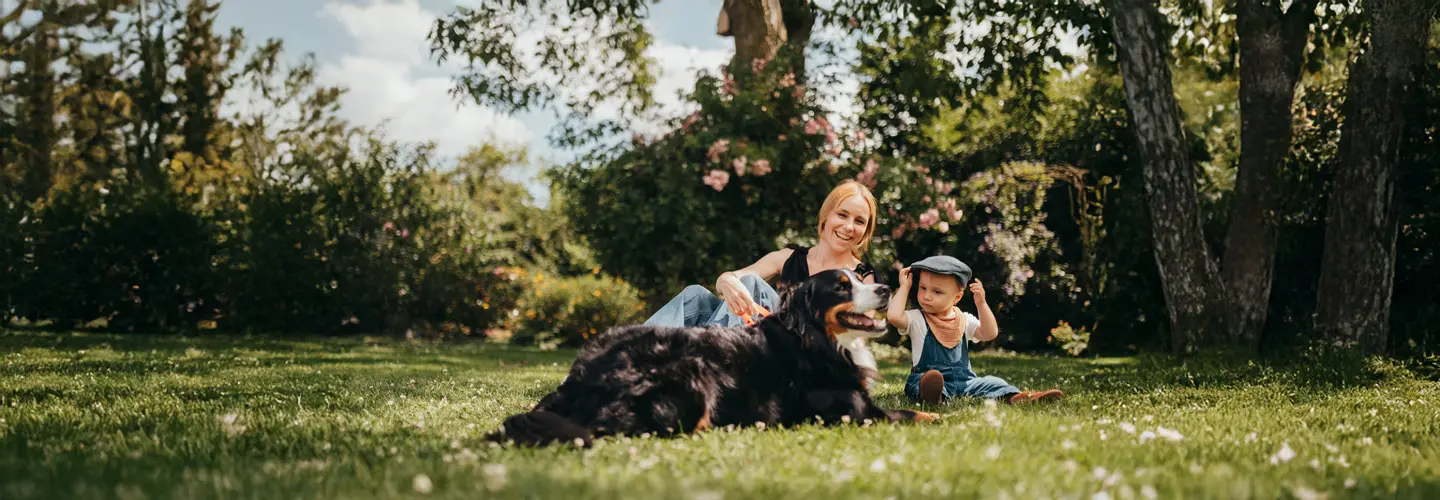 Frau mit Kind und Hund auf der Wiese