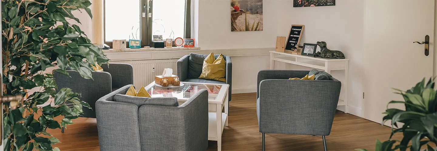 Das Bild zeigt einen modernen Warteraum in der ROSENGARTEN Tierbestattung Filiale mit Pflanzen und gemütlicher Einrichtung.