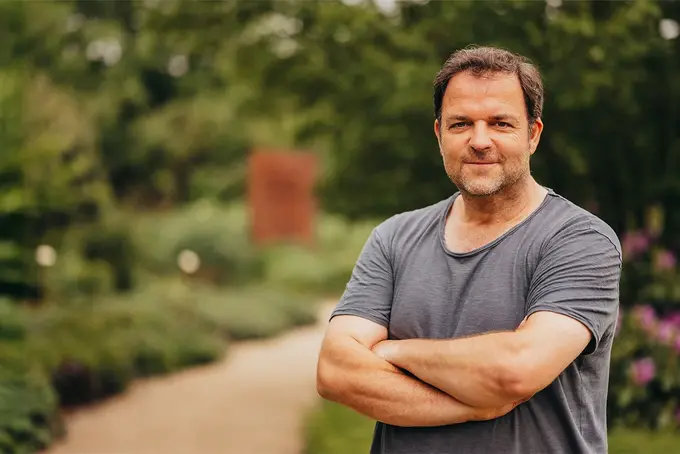 Foto von Martin Rütter. Im Hintergrund ist ein Weg und grünes Pflanzenwachstum sichtbar.