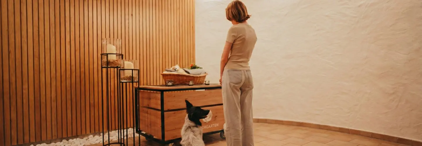 Frau verabschiedet sich von ihrem Hunde gemeinsam mit ihrem zweiten Hund.