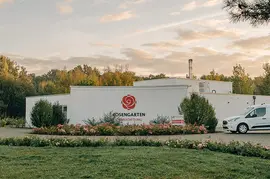 Das **ROSENGARTEN Tierkrematorium Spreewald** inmitten grüner Natur, umgeben von Blumen und Bäumen.