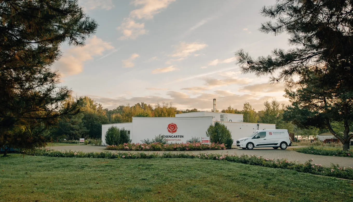 Luftaufnahme des Rosengarten Tierbestattung Gebäudes mit gepflegtem Garten und Firmenfahrzeug.