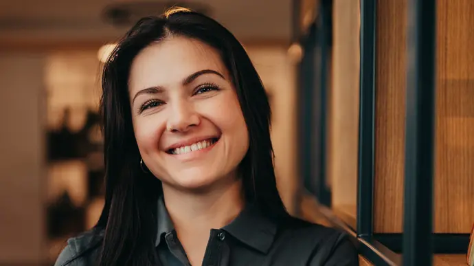 Frau steht an einem Regal für Urnen in einem großen Kundenraum.