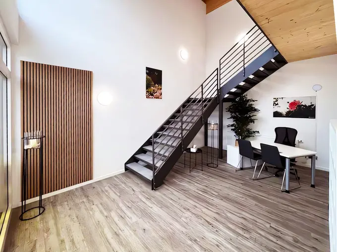 Heller, moderner Büro-Innenraum mit offener Stahl-Holz-Treppe, warmem Holzfußboden und klarer Architektur, der Ruhe, Struktur und eine inspirierende Arbeitsatmosphäre ausstrahlt.